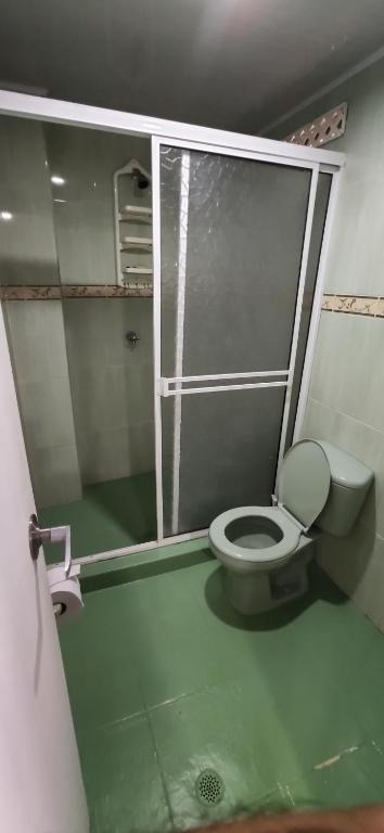 bagno con servizi igienici e porta in vetro. di Sarie Bay Inn a San Andrés