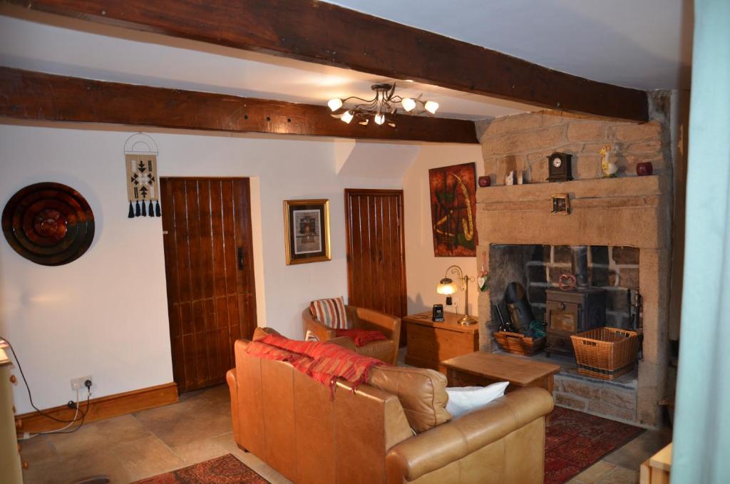 sala de estar con sofá y chimenea en Charming 2-Bed Cottage in Hebden Bridge en Hebden Bridge