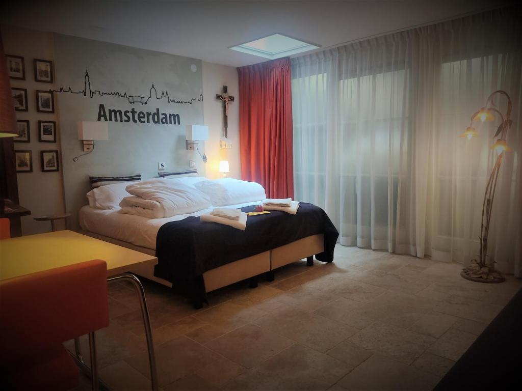 a bedroom with a bed and a table in a room at Studio53Amsterdam in Amsterdam