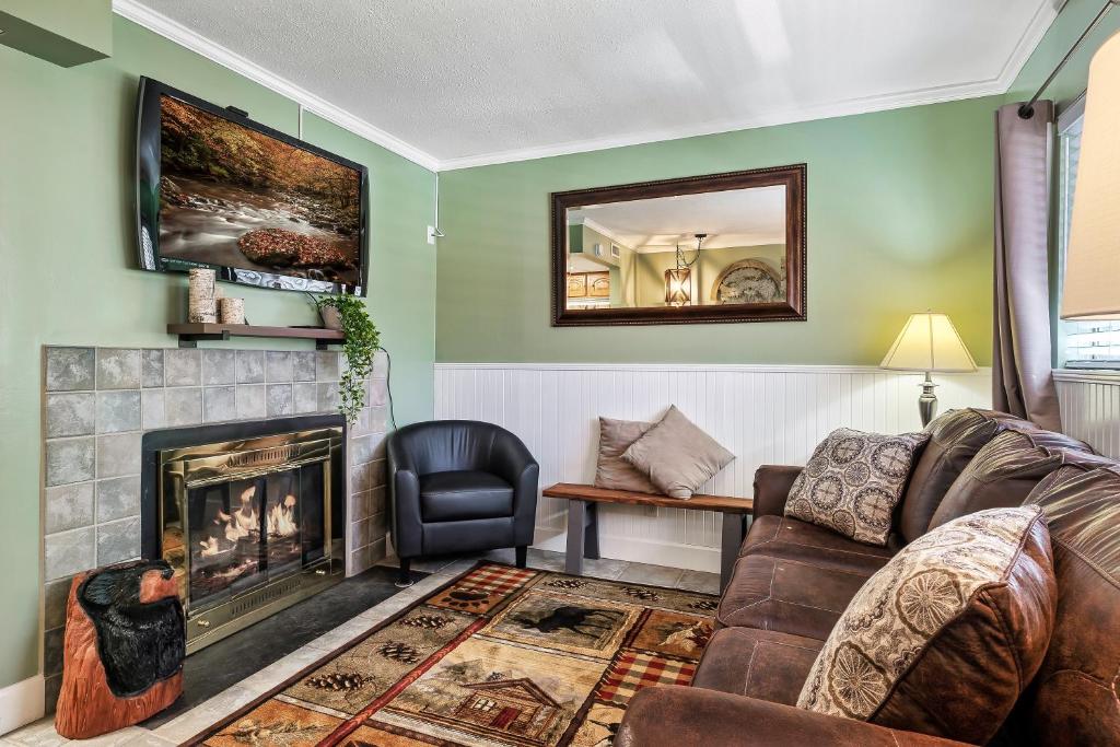 a living room with a couch and a fireplace at Lovely condo w/ indoor pool *only steps to parkway in Gatlinburg