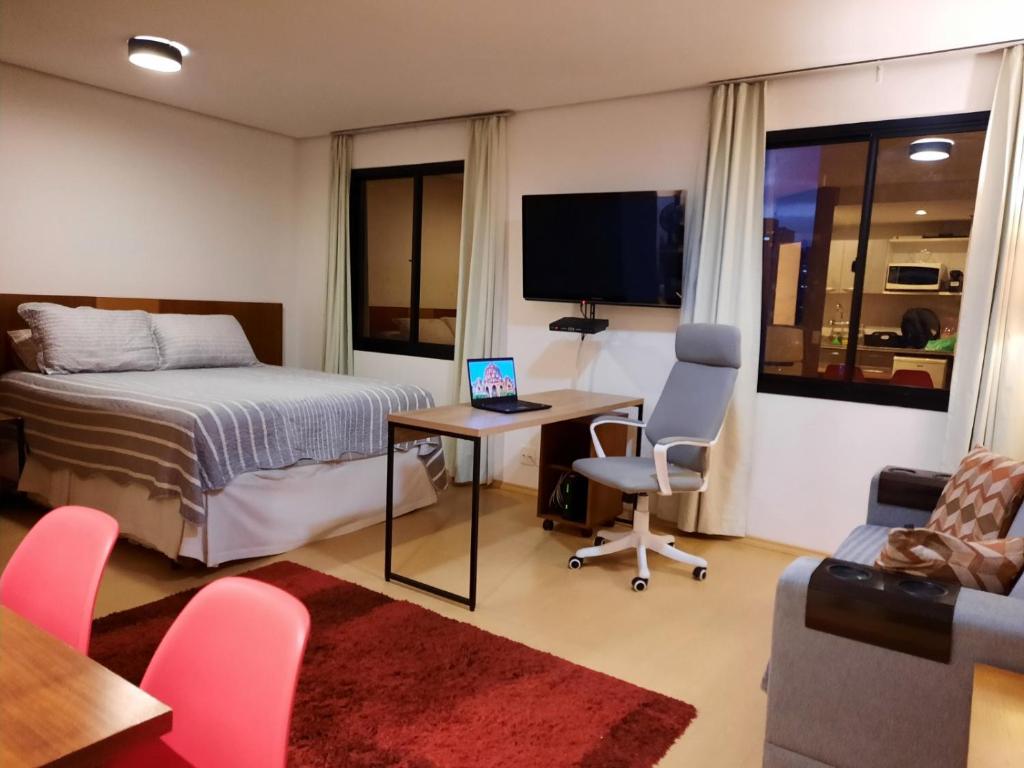 a bedroom with a bed and a desk with a computer at Studio Mercure Hotel Moema - Av. Jamaris 100 in Sao Paulo
