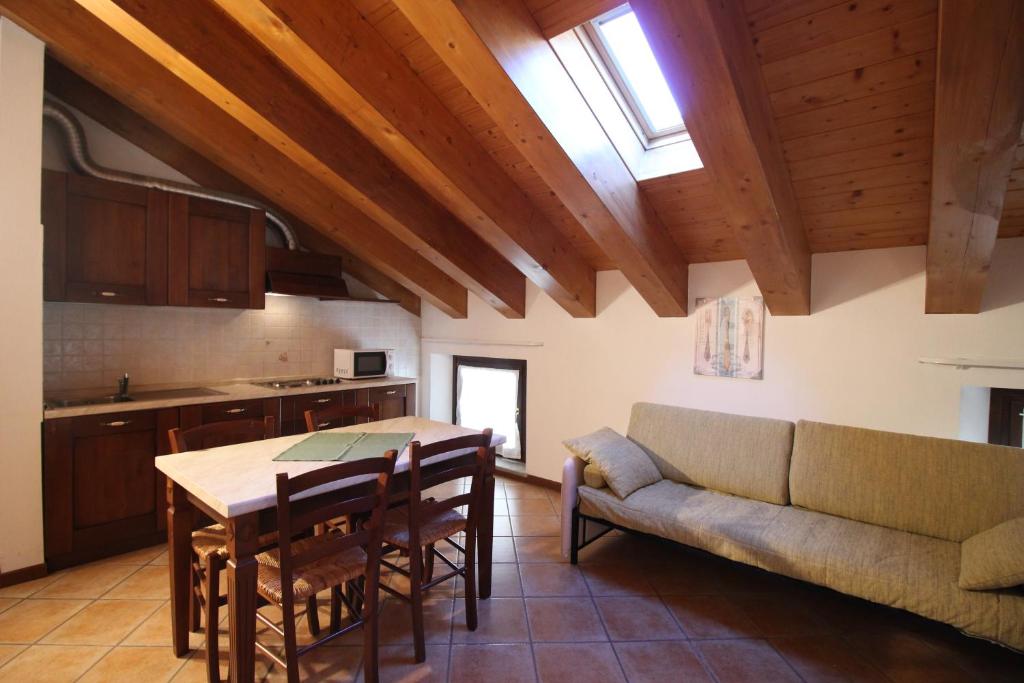 kuchnia i jadalnia ze stołem i kanapą w obiekcie Residence Aquila - Mono Corno Vitello w mieście Brusson