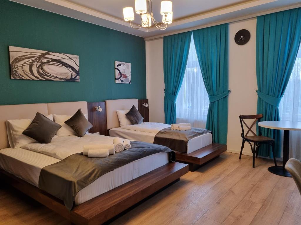 - une chambre avec 2 lits aux murs bleus et une table dans l'établissement A&F Hotel Chemnitz, à Chemnitz