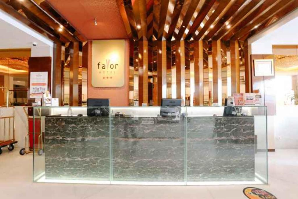 eine Lobby mit einem Glastresen in einem Gebäude in der Unterkunft Favor Hotel Makassar City Center By LIFE in Makassar