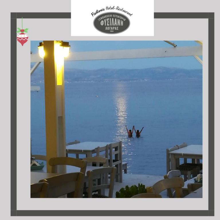 two people are in the water in the ocean at Fisilanis Beachfront Hotel in Logaras