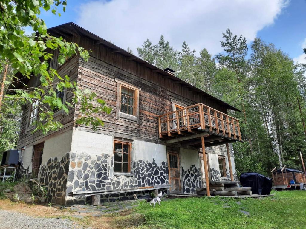 een huis met een terras aan de zijkant bij Seitsemisen Torpat Log Cabin in Latovesi