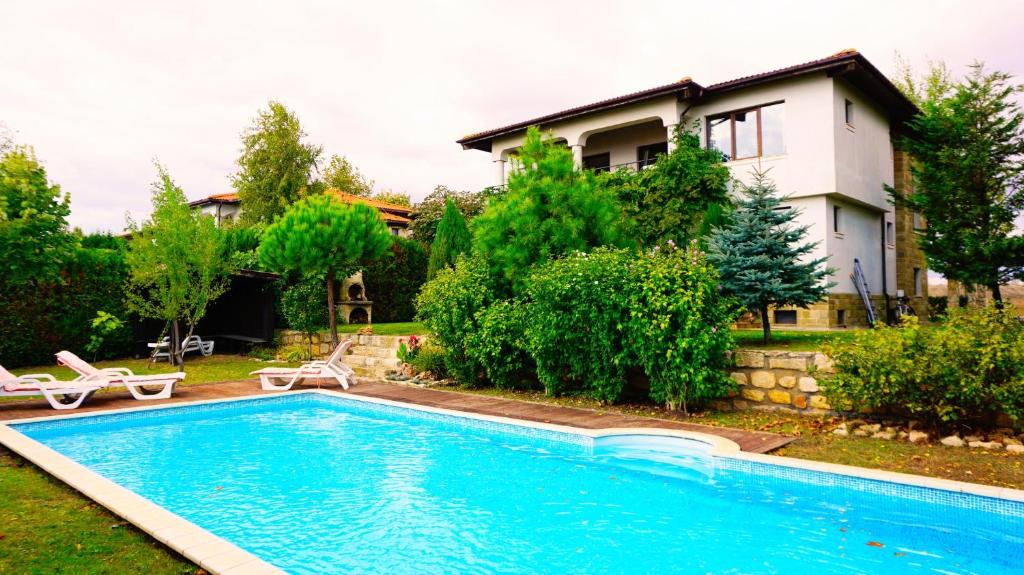 a swimming pool in front of a house at Вила Афина - Villa Afina in Balchik