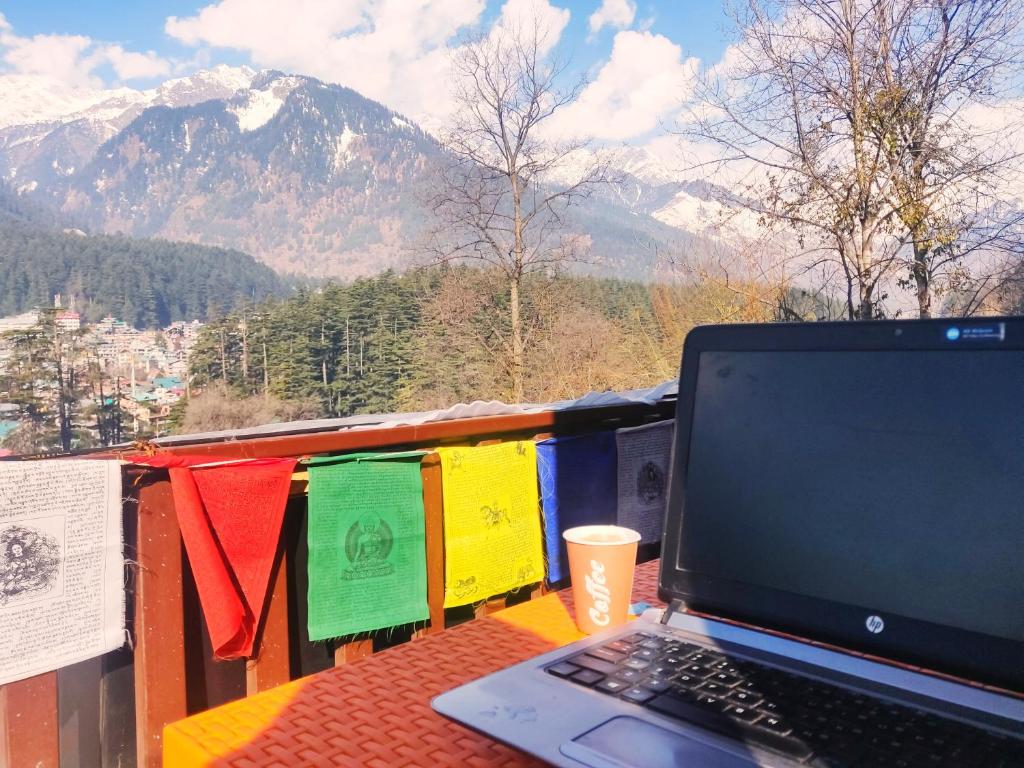 un computer portatile seduto su un tavolo con vista su una montagna di Cupidtrails Himalayan Castle a Manāli