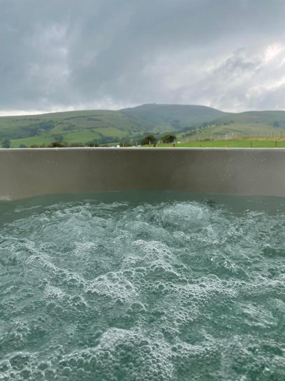 a tub filled with water with at Famau Cabins Gwel Y mynudd in Cilcain