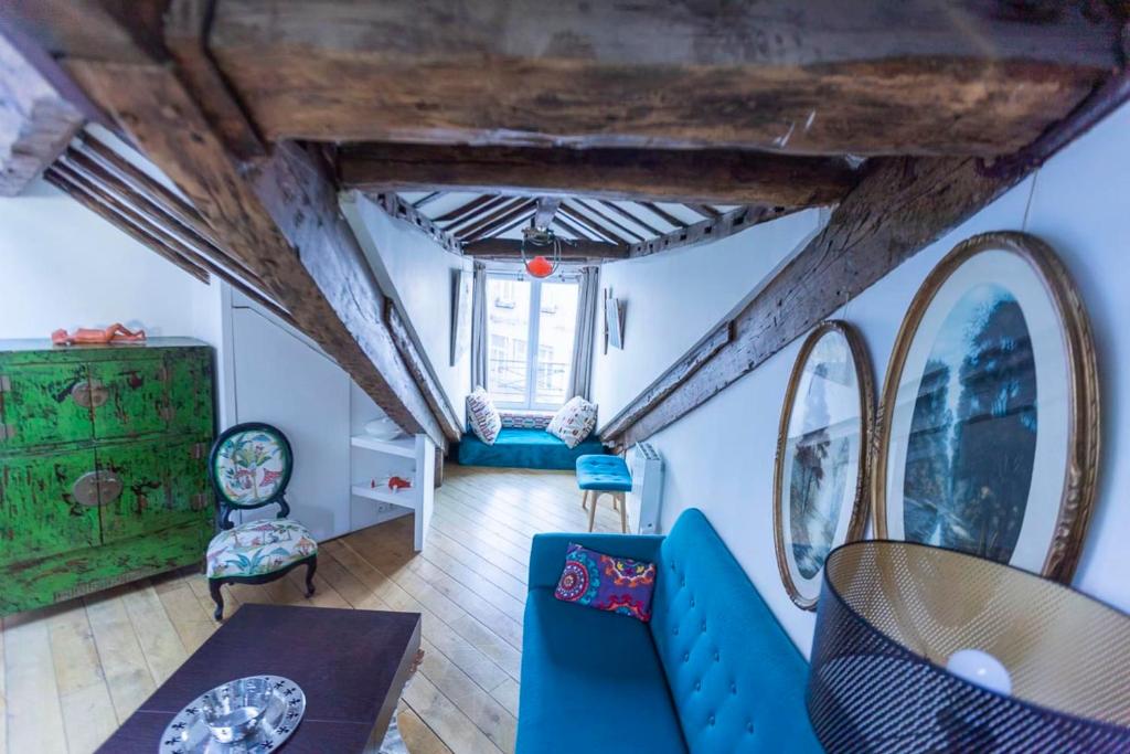 un salon avec un canapé bleu et des chaises dans l'établissement Spacious Apartment Near The Palais Garnier, à Paris