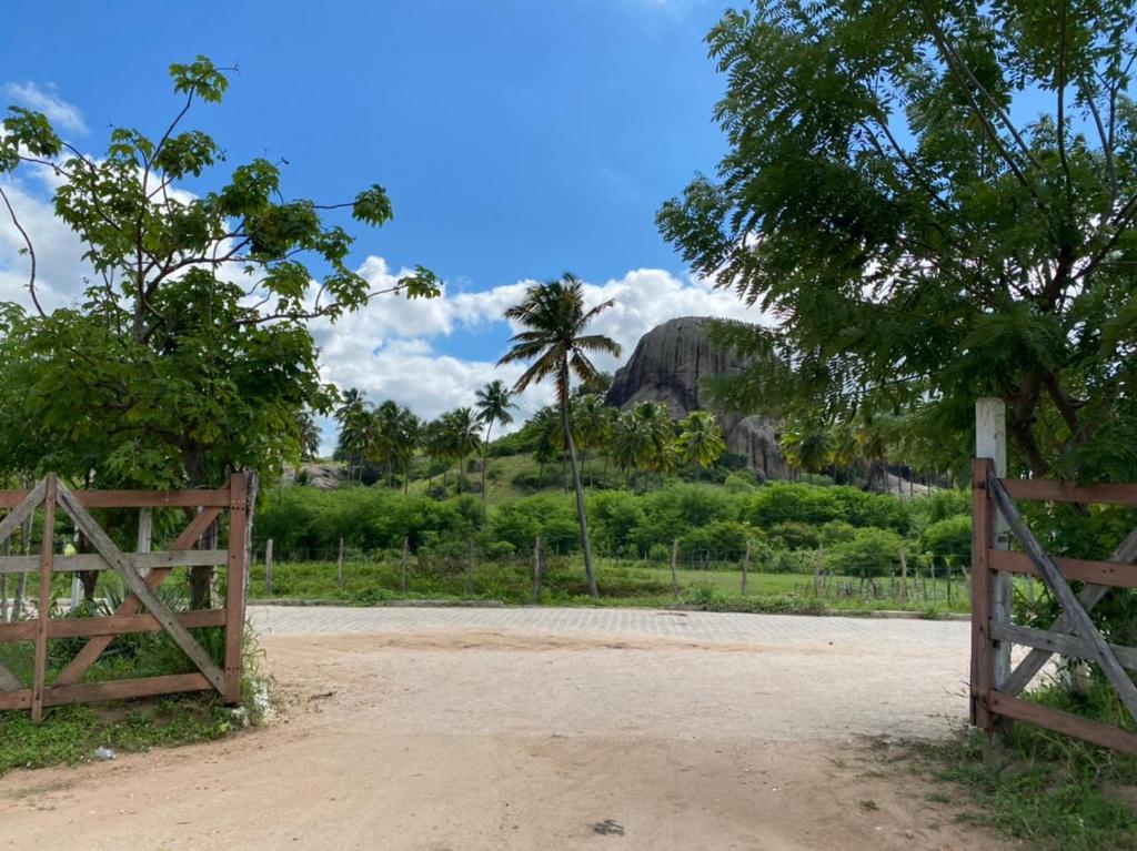 una puerta en un campo con una montaña en el fondo en Pousada Princesa do Agreste, en Passa e Fica