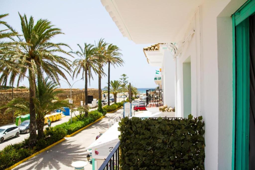 a balcony with a view of a street and palm trees at Hotel Avenida Playa in Zahara de los Atunes