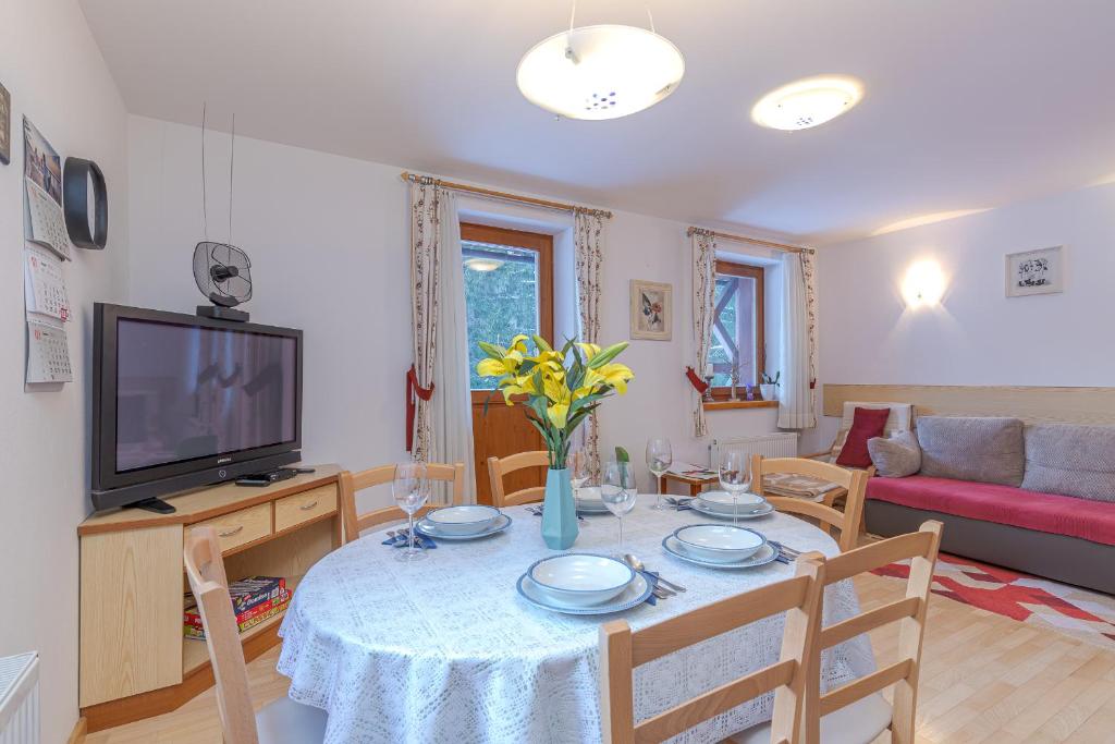 a living room with a dining room table and a television at Apartma Gaja in Kranjska Gora