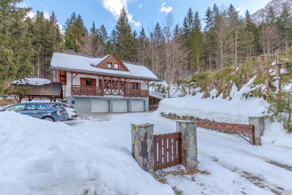 a house with a car parked in the snow at Apartma Gaja in Kranjska Gora