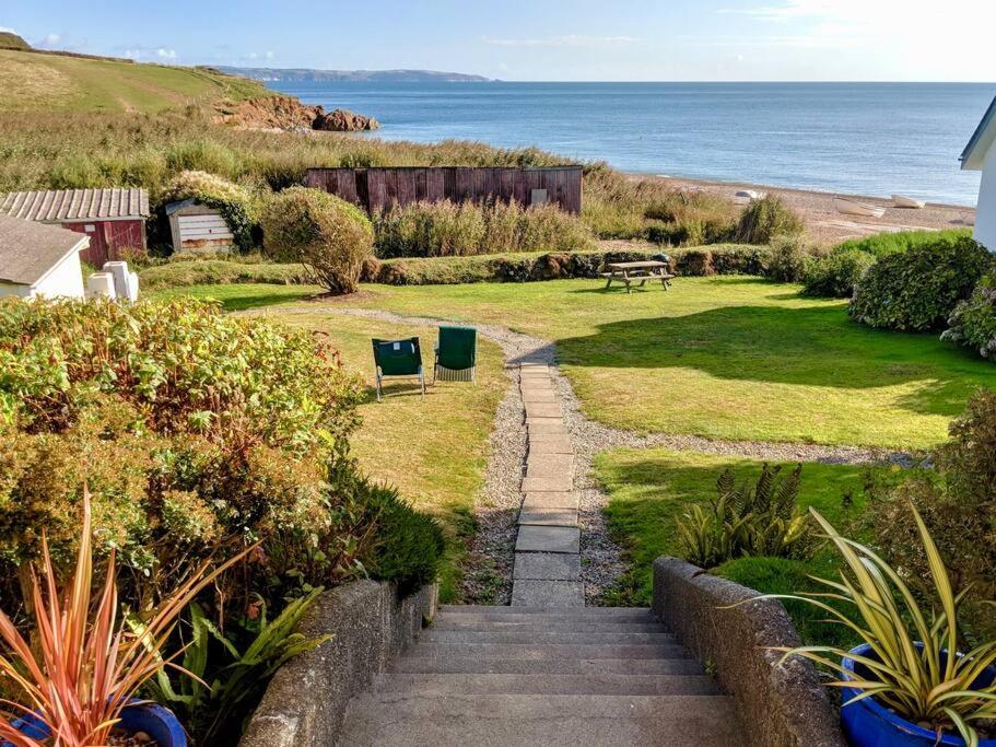 a stairway leading to a garden with a view of the ocean at Beach Front Coastal Retreat with Sea Views in Kingsbridge