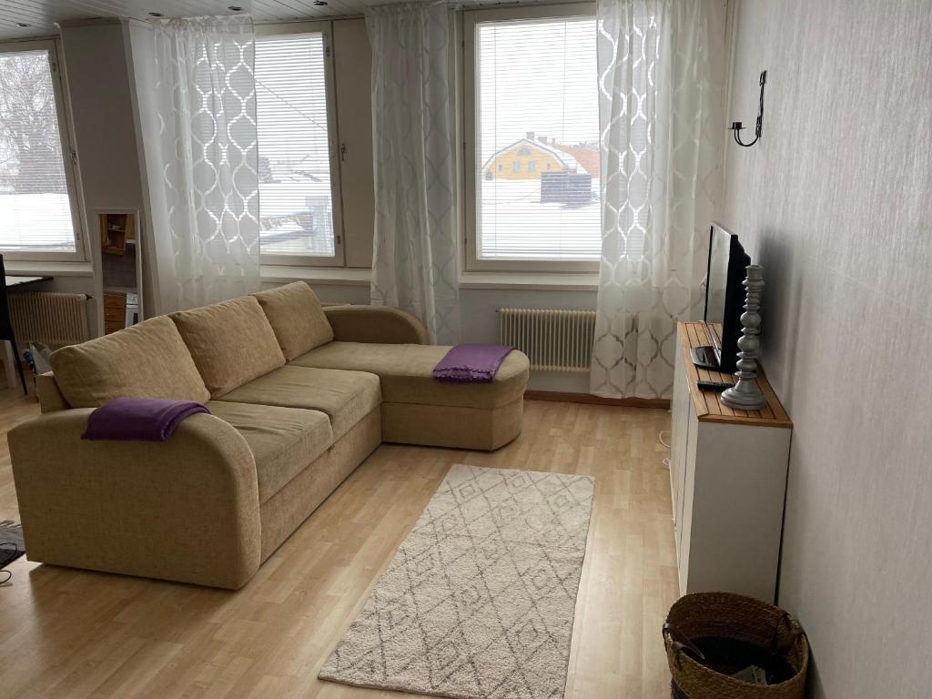 a living room with a couch and a tv at Apartment Isokatu in Kokkola