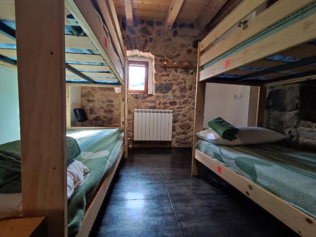 a room with two bunk beds in a house at Albergue El Rebezo in Torrebarrio