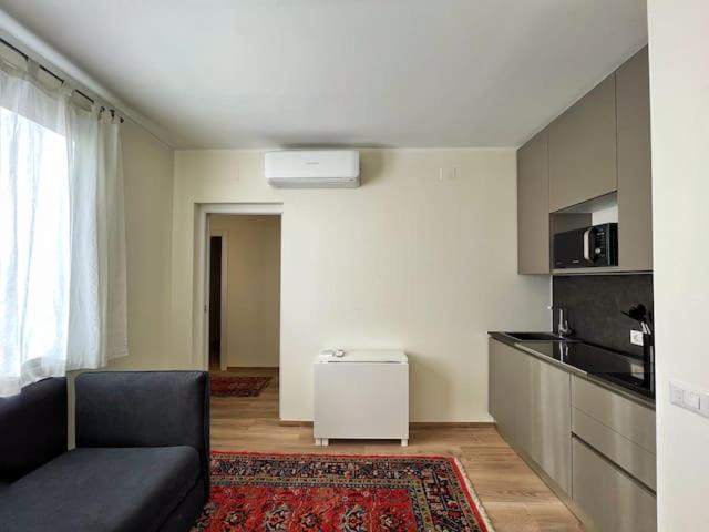 uma sala de estar com um sofá e uma cozinha em Extravaganza Room and Suite Apartment City Center em Cagliari