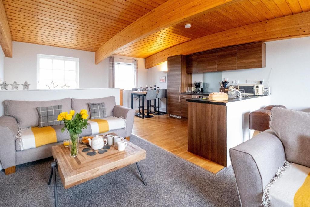 Sala de estar con 2 sofás y mesa en The Loft - Aldeburgh Coastal Cottages, en Leiston