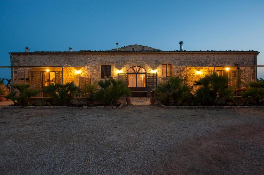 une maison en pierre avec des lumières devant elle dans l'établissement Masseria Boscorotondo, à Scicli