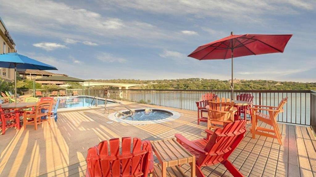 a deck with chairs and a table with an umbrella at Hidden Falls Inn in Marble Falls