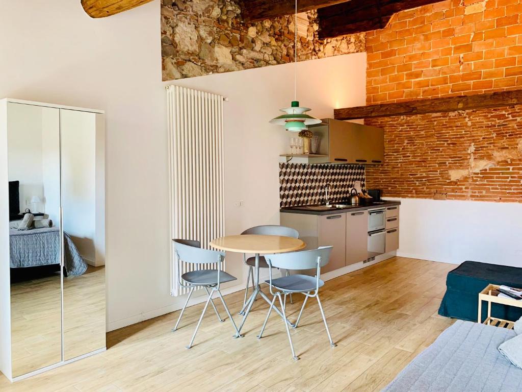 kuchnia ze stołem i krzesłami oraz ceglaną ścianą w obiekcie UnicumHouse Verona w Weronie