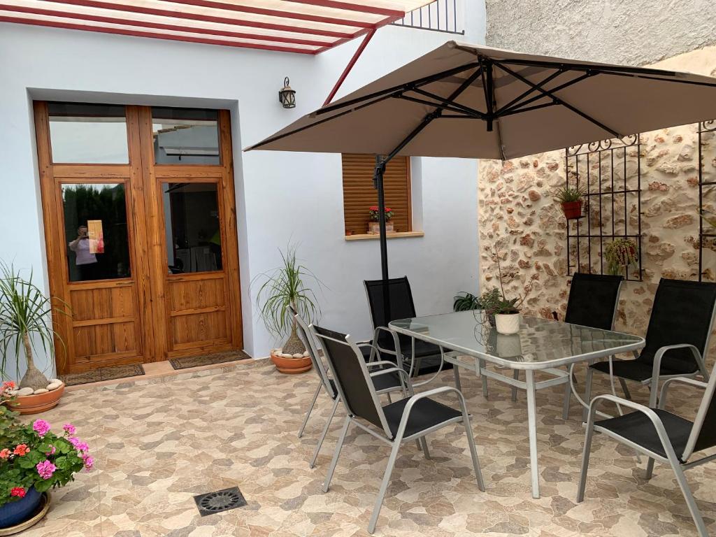 a table and chairs with an umbrella on a patio at Ca La Martí in Pedreguer