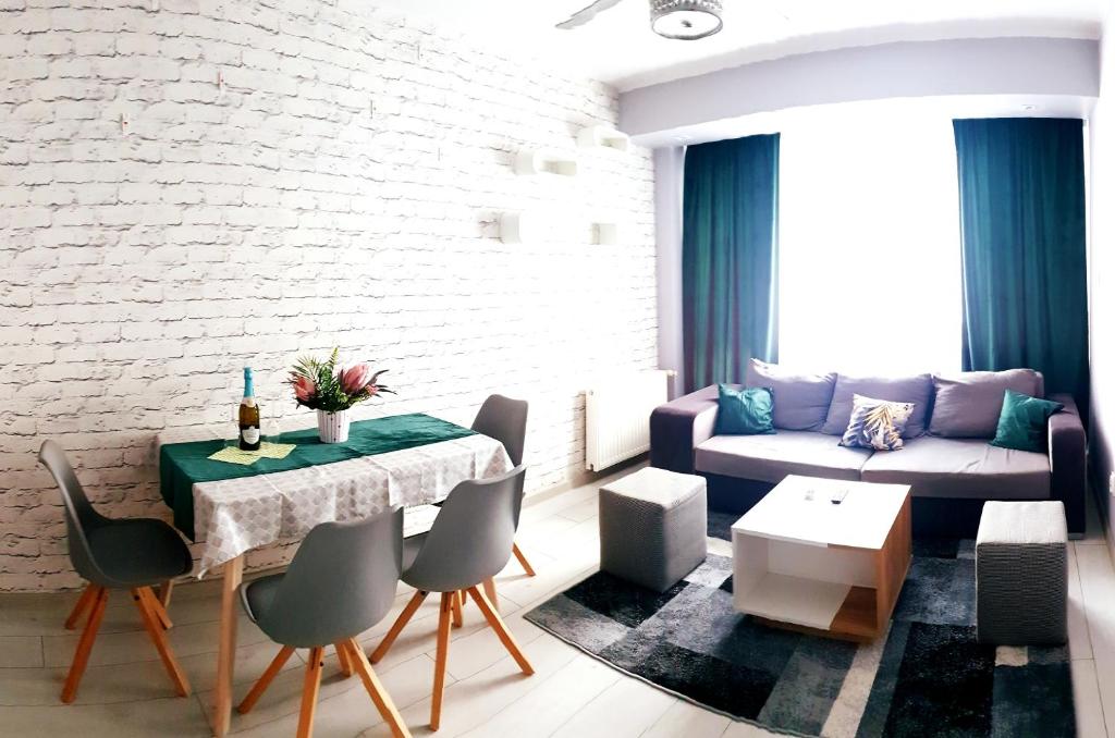 uma sala de estar com uma mesa e um sofá em APARTAMENT 2+2 em Konin