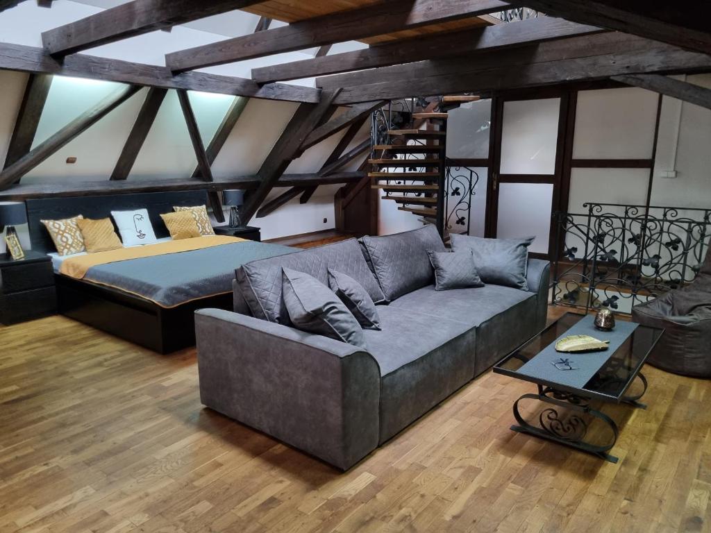 a living room with a couch and a bed at Galerie Vila Lucia 5 -Loft apartmán in Pilsen