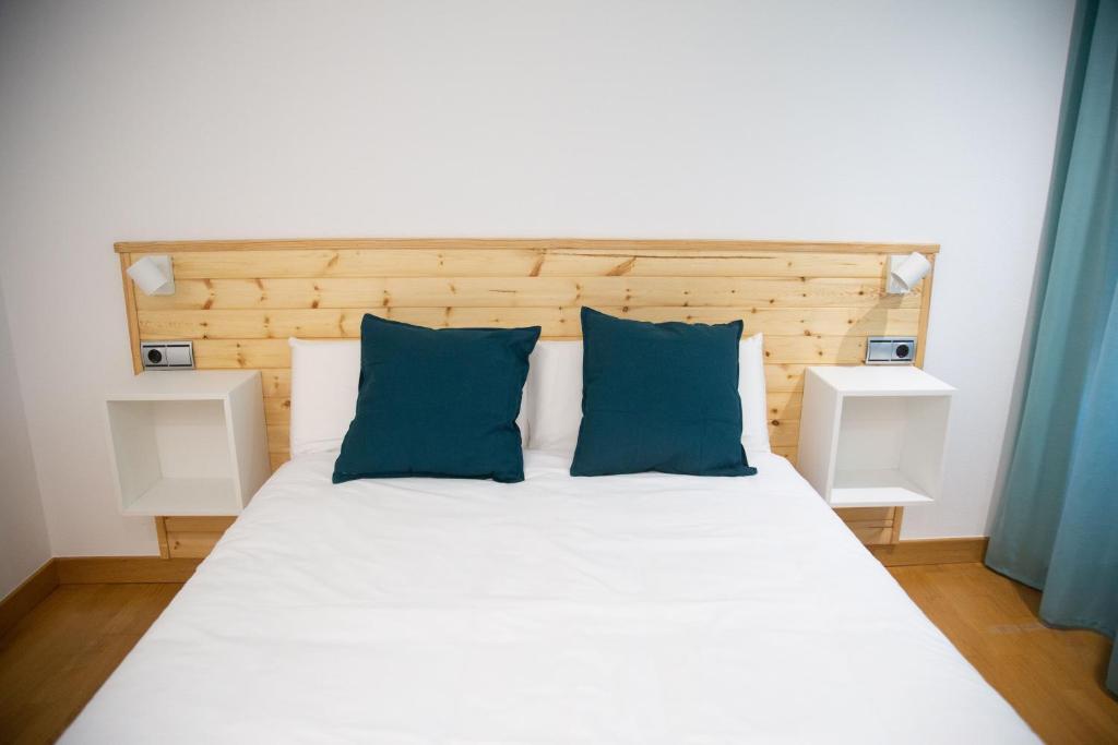 1 dormitorio con cama blanca y almohadas azules en SAN MARCOS, en Almansa