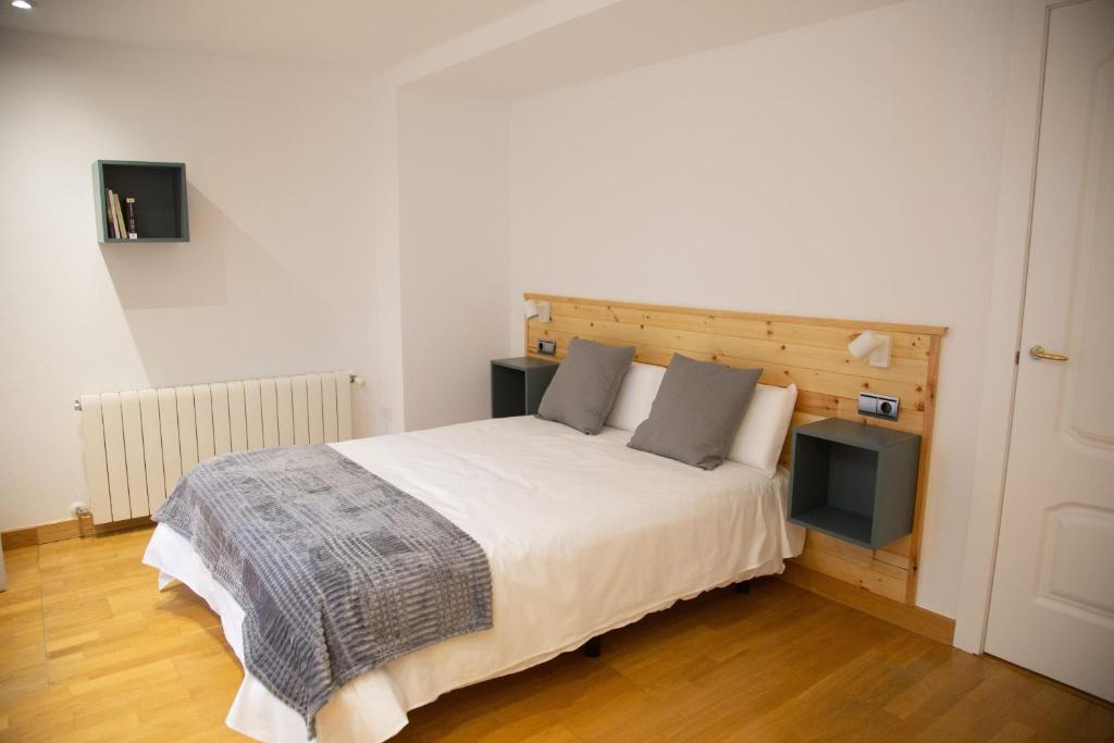 a bedroom with a large bed with a wooden headboard at ELIZABETH TOWERS in Almansa