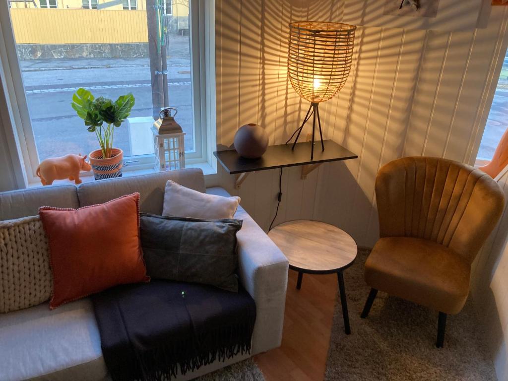 a living room with a couch and a chair and a window at Downtown Historical House with Renovated apartments in Ålesund