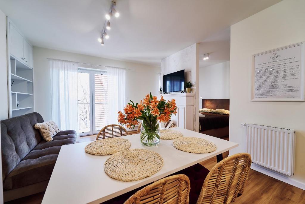 a living room with a table with chairs and a couch at Blanca Apartamenty Polanica-Zdrój, Polanica Residence in Polanica-Zdrój