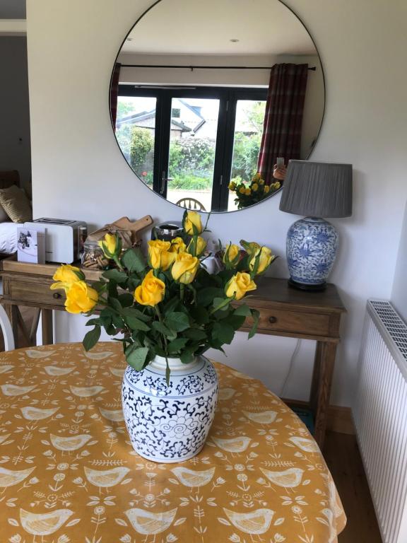 a vase filled with yellow flowers sitting on a table at City Central Quiet Garden Studio with Free Parking in Inverness