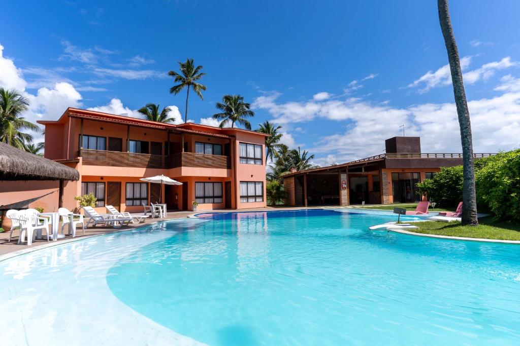 una gran piscina frente a un edificio en Pousada Un Paso del Mar en Porto De Galinhas