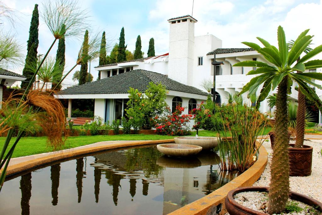una casa con un estanque frente a una casa en Santo Refugio Heritage Hotel, en Cholula