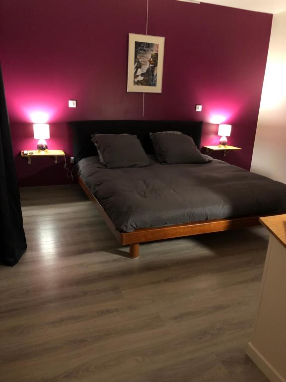 - une chambre avec un lit aux murs violets et 2 lampes dans l'établissement Ain’Time, à Biziat