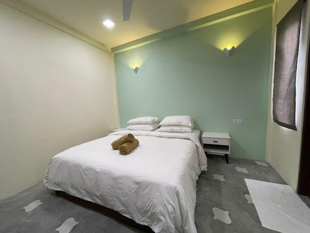 sypialnia z łóżkiem z wypchanym zwierzakiem w obiekcie Courtyard Guesthouse w mieście Huraa