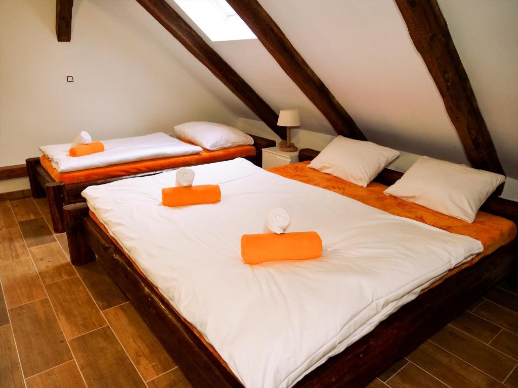 two beds in a room with orange and white sheets at Apartmánový dům 13 Mezonet 1 in Seč