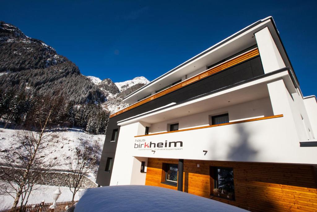 ein Gebäude in den Bergen mit Schnee auf dem Boden in der Unterkunft Birkheim in Ischgl