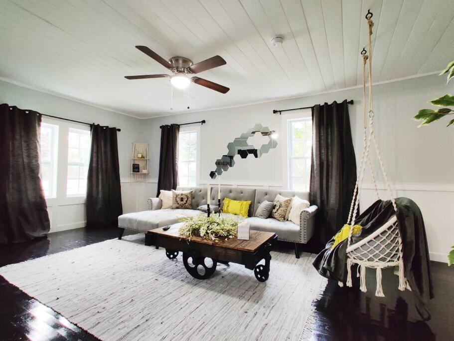 uma sala de estar com um sofá e uma ventoinha de tecto em HoneyComb GEM, Beautifully Designed & Near Downtown Thomasville em Thomasville