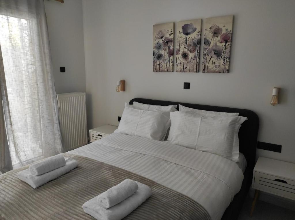 una camera da letto con un letto con due asciugamani sopra di Polyxenia’s Πλησίον Υγεία - Μητέρα - Ιασώ - ΟΑΚΑ ad Atene