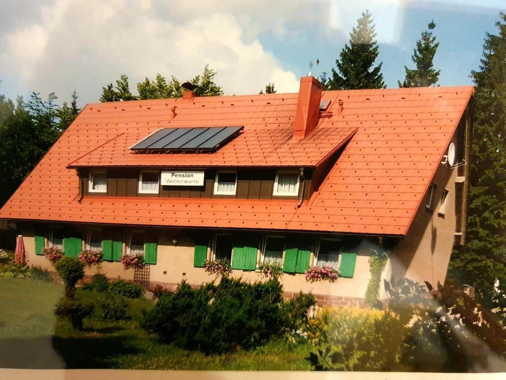 uma casa com painéis solares no telhado em Ferienhaus am Rennsteig-Pension zur Wetterwarte em Brotterode