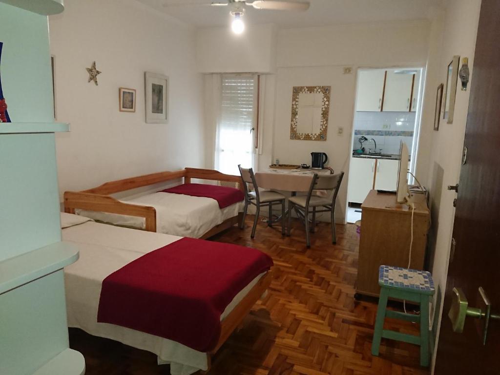 a bedroom with two beds and a table and a kitchen at AGRADABLE STUDIO EN PALERMO in Buenos Aires