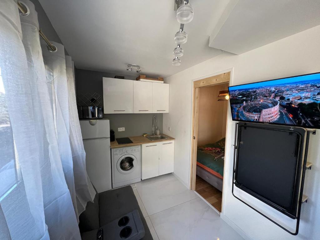 a small kitchen with a tv on the wall at Superbe appartement entre lac et montagne. in Veyrier-du-Lac
