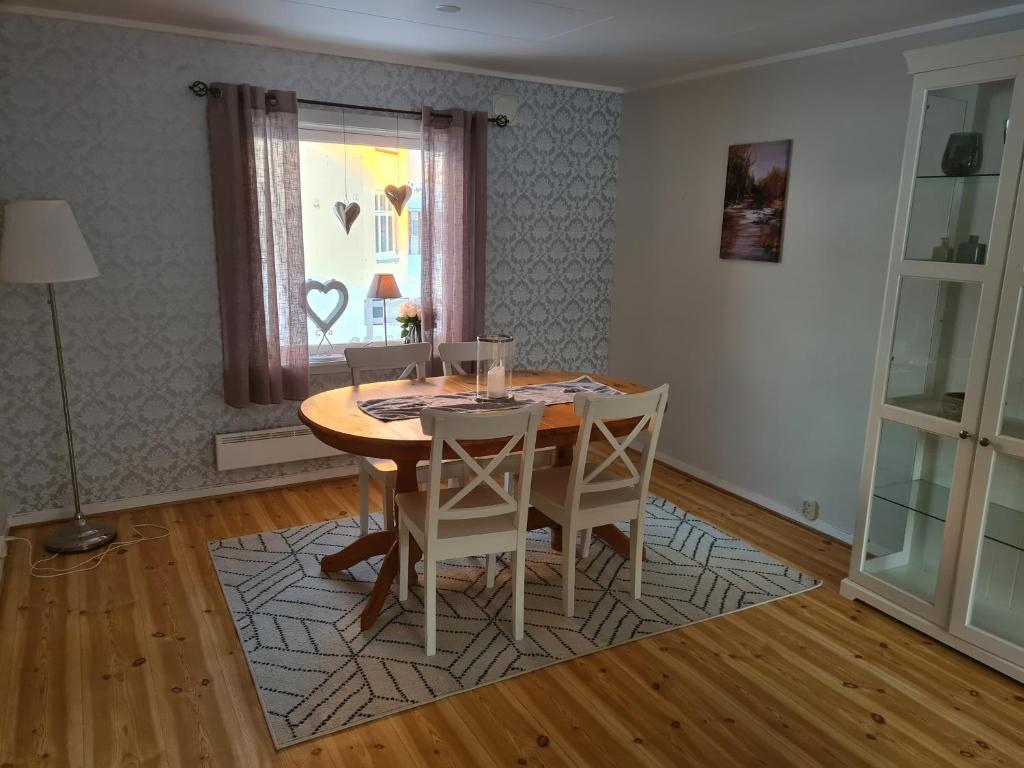 ein Esszimmer mit einem Tisch, Stühlen und einem Fenster in der Unterkunft Festningsgaten 3 b in Vardø