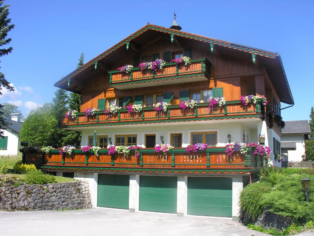 ein Haus mit einem Balkon mit Blumen darauf in der Unterkunft Pension Köberl in Bad Mitterndorf