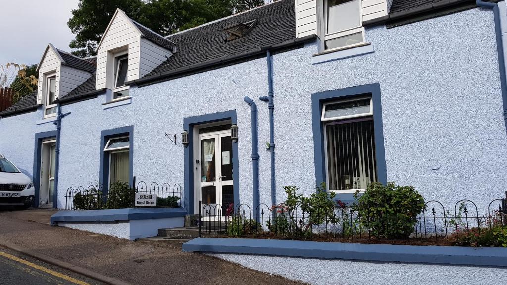 
a blue and white house with two windows at Braeside Guest Rooms in Portree
