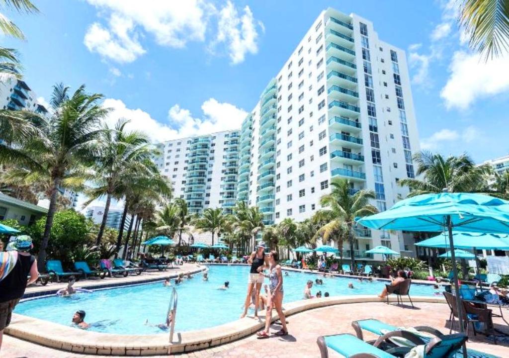 einen Pool in einem Resort mit Leuten darin in der Unterkunft The Tides on Miami Hollywood Ocean View Apartments 1B in Hollywood