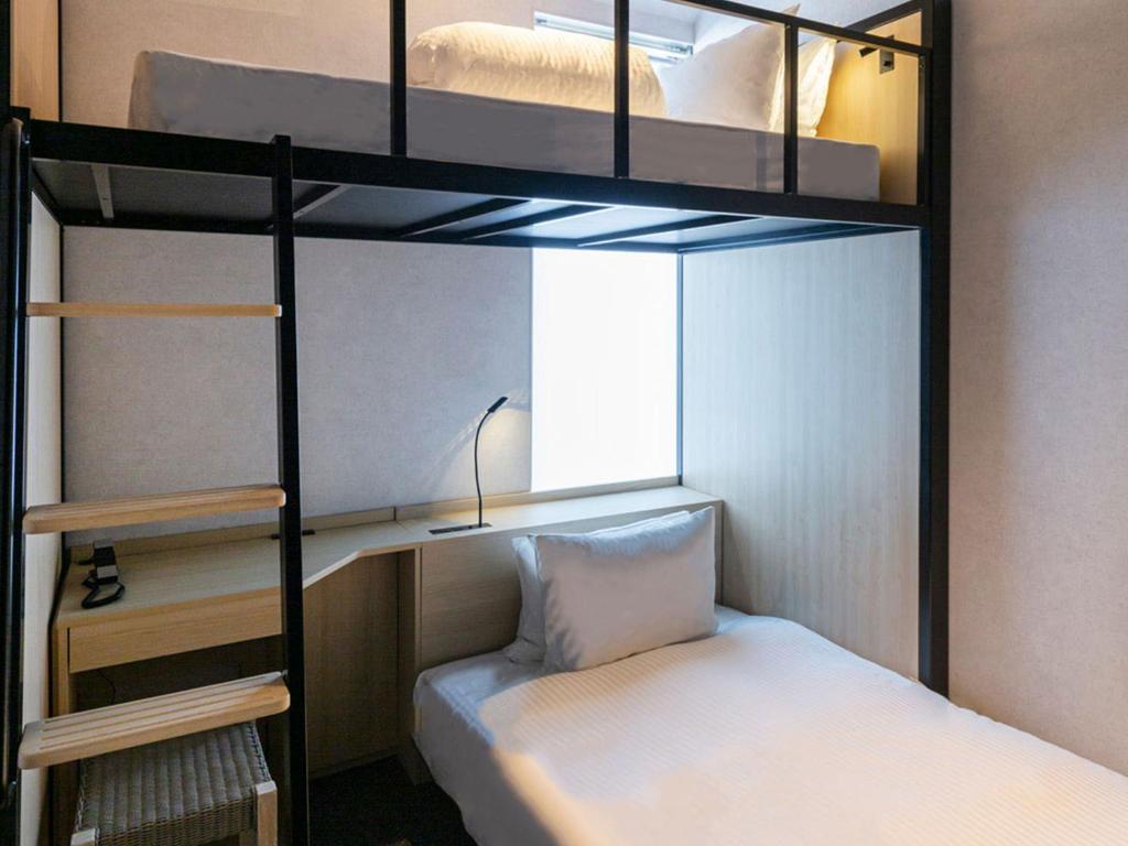 Postel nebo postele na pokoji v ubytování Akabane Holic Hotel